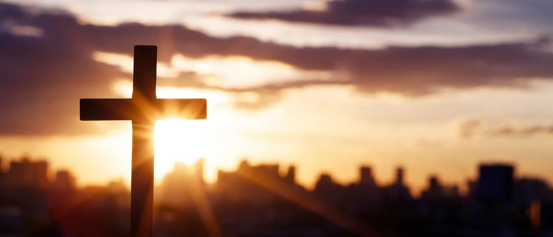 Wooden cross against sunrise sky